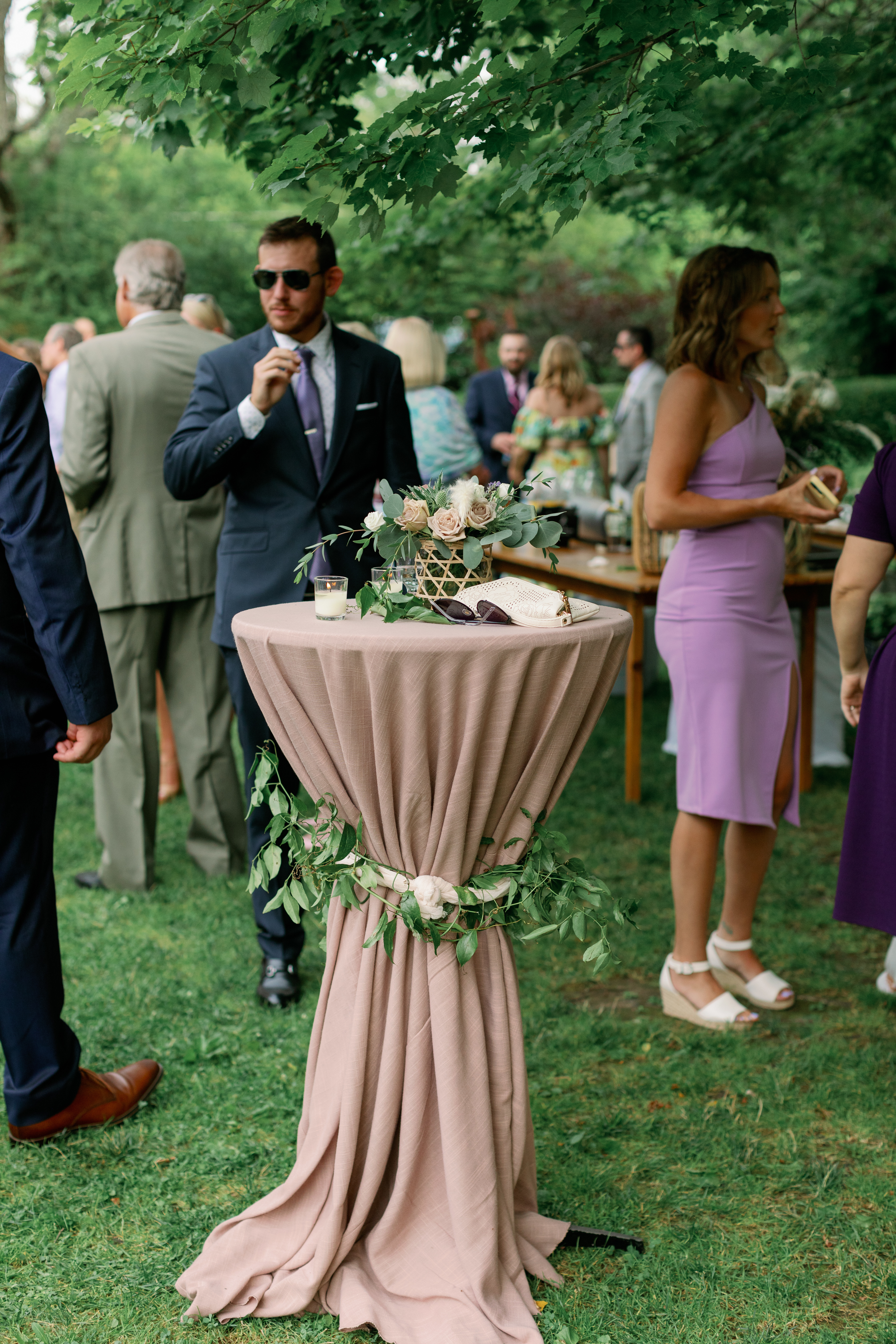 wedding reception outdoors featuring a high table with flowers on it
